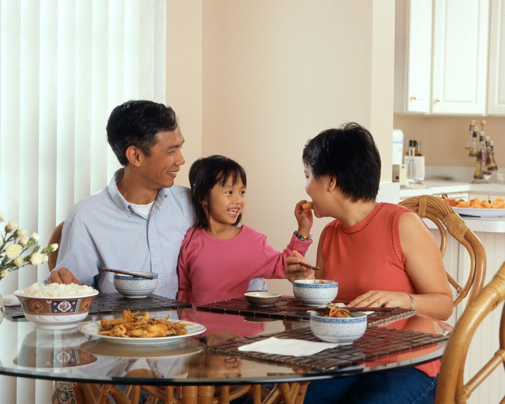 Family with a young child sitting at dinner table together