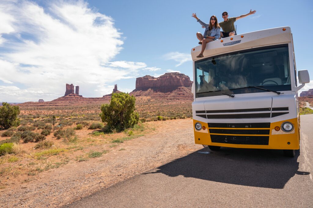 couple sitting on RV at park with buttes